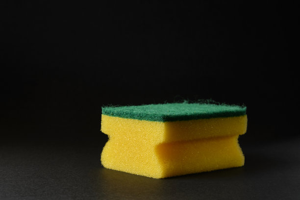 黑色背景下的单一黄色海绵图片下载