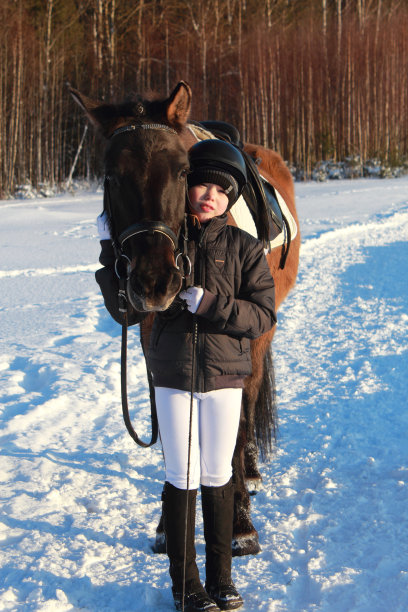 特写小男孩和马在冬天。图片下载