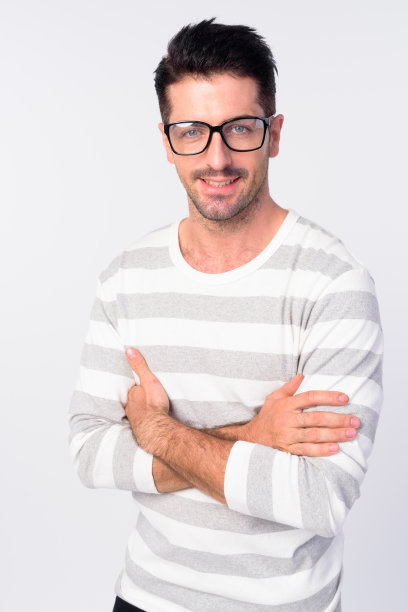 一幅快乐的大胡子男人的肖像，戴着眼镜，微笑着，双臂交叉图片下载