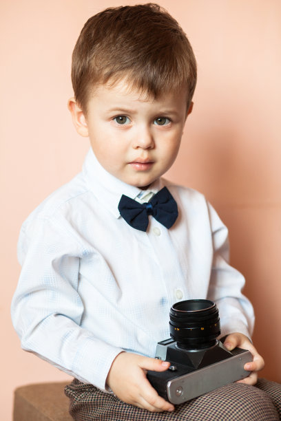 带着老式照相机的小男孩。拿着旧相机的孩子图片下载