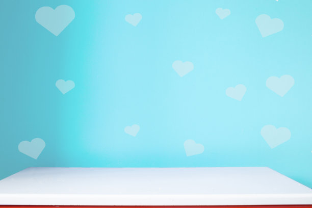 空白的白色桌子上模糊的蓝色心墙背景素材图片