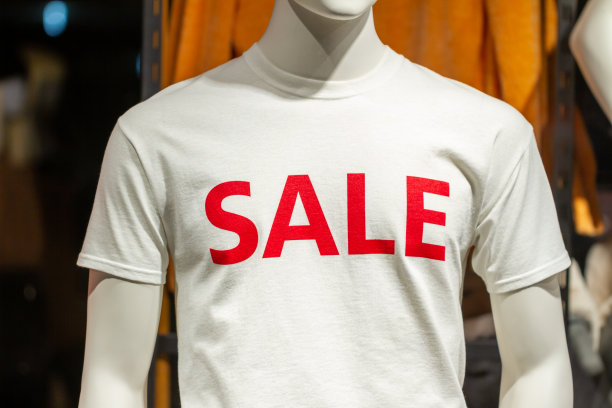 男性上半身假人在商店展示，上面写着“销售”的字样。消费主义和低价观念。图片下载