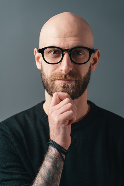 在灰色背景下，时尚的年轻人在工作室里摆姿势图片下载