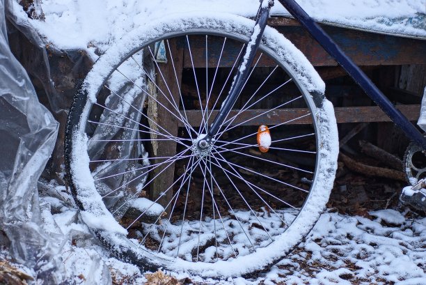 一个旧自行车的一部分，有一个轮子在白色的雪图片下载