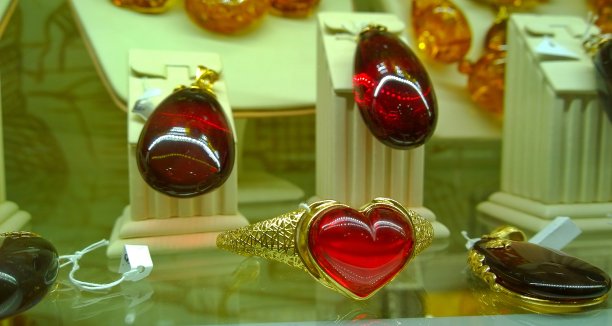 商店货架上的红色琥珀首饰。优雅美丽不寻常的手镯与一颗石头的形状的心。风格和时尚概念。情人节。为心爱的人准备一个很棒的节日礼物图片下载