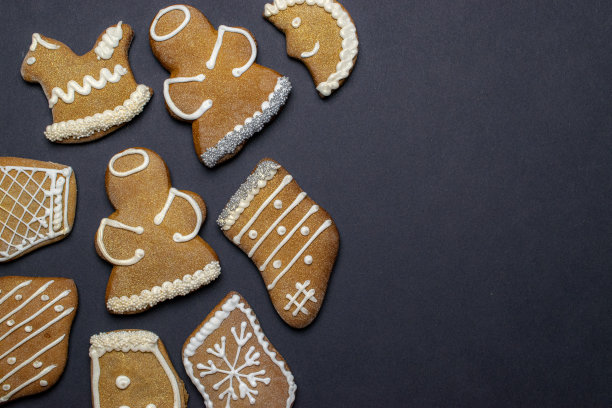 姜饼人。圣诞自制姜饼，蜂蜜饼在黑色背景上。圣诞贺卡，横幅。寒假圣诞主题。新年快乐。空间的文本图片下载