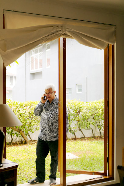 年长的成年人在家使用手机图片下载