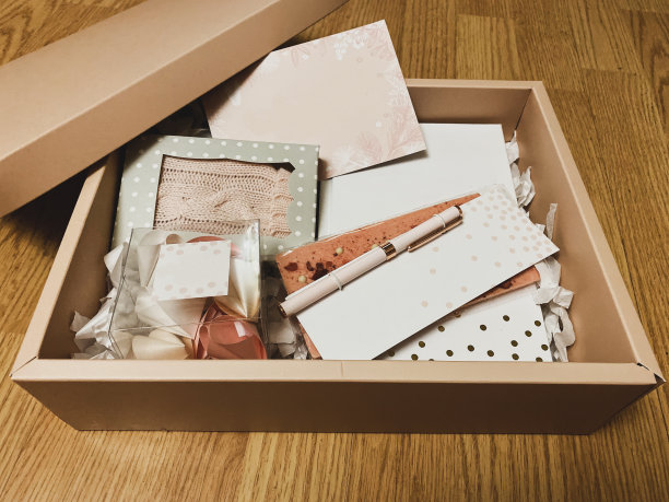 礼物套装在一个粉红色的盒子里，有一个笔记本，钢笔，巧克力棒和幸运饼干图片下载