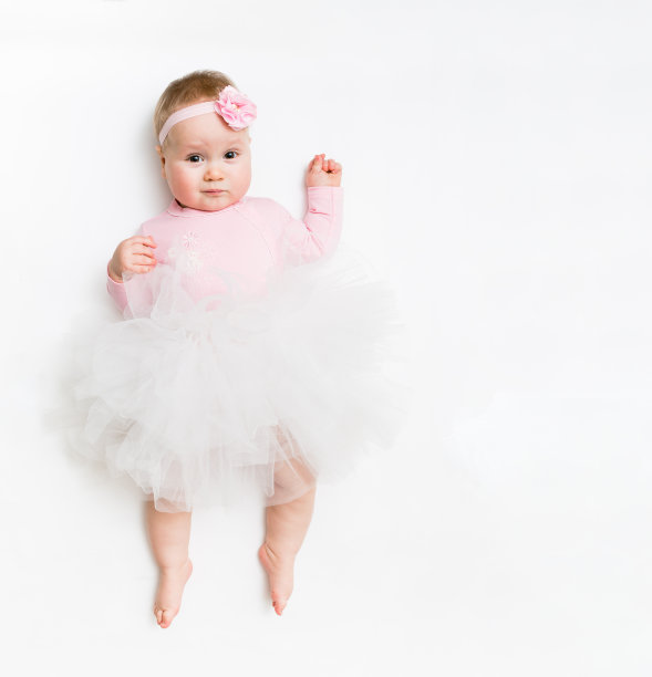 一个可爱的婴儿的肖像穿着粉红色的芭蕾舞裙和头带蝴蝶结，孤立在白色的工作室图片下载