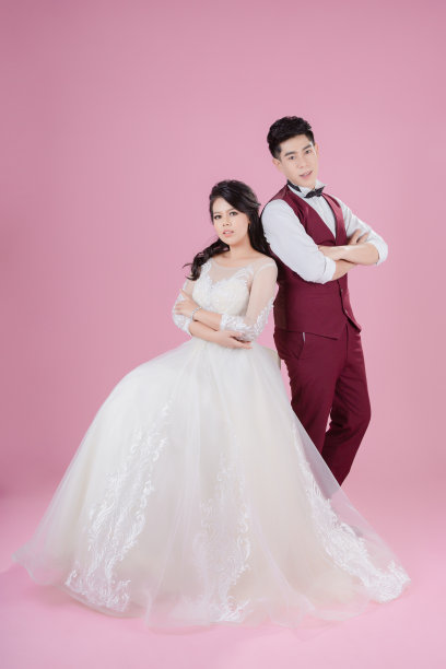 粉色背景上的年轻新娘和新郎是幸福的。新婚夫妇，新家庭，婚纱。新娘的婚礼。爱的概念图片下载