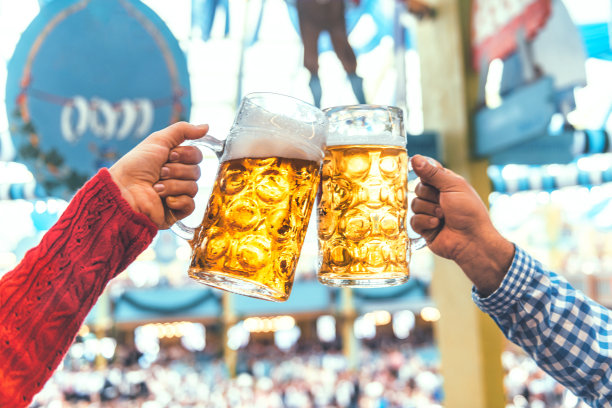 在慕尼黑啤酒节上，两只手碰杯图片下载