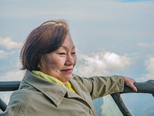 肖像照片美丽的亚洲妇女与美丽的风景天门山和晴朗的天空在中国张家界城市。图片下载