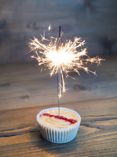 木背景上放着发光的小蛋糕图片下载