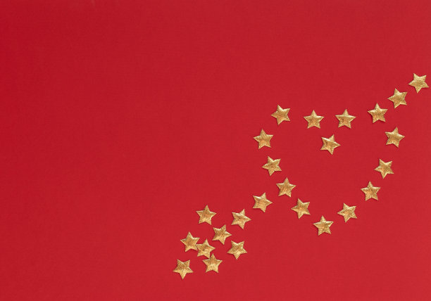 情人节的红色背景用心形和箭头做成的小金色星星。情人节贺卡或请帖。爱、幸福的概念。平躺，顶视图样式与复制空间的文本。图片下载