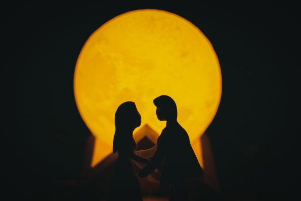 年轻的一对年轻的男人和女人是一对恋人，他们是黑暗中用泥土做的木偶。图片下载