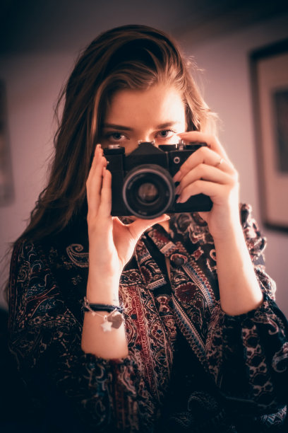 小女孩拿着相机站在镜子前自拍图片下载