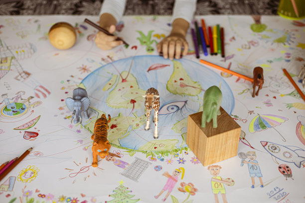 一个小女孩被塑料玩具动物和用铅笔画的木制几何图形包围着图片下载