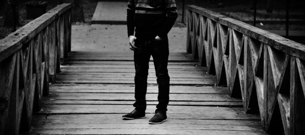 一个穿着黑色礼服的男人站在木桥上图片下载
