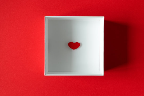 小木心在白色礼盒上的红色背景，上面。情人节的惊喜图片下载