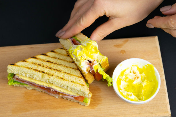 靠近一对年轻女孩的手移走一个健康健康的全麦面包火腿三明治图片下载