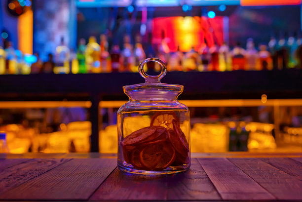 干柠檬在一个透明的玻璃罐子在酒吧桌上。图片下载