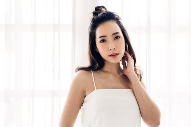 在墙壁背景前摆姿势的时尚美女模特肖像图片下载