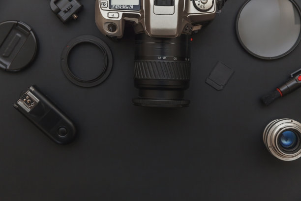 摄影师工作场所的数码单反相机系统，相机清洁套件，镜头和相机配件在暗黑色的桌子背景。爱好旅游摄影概念。平放俯视图拷贝空间图片下载