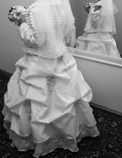 新娘身着传统服饰，皮草大衣，手持婚礼花束图片下载