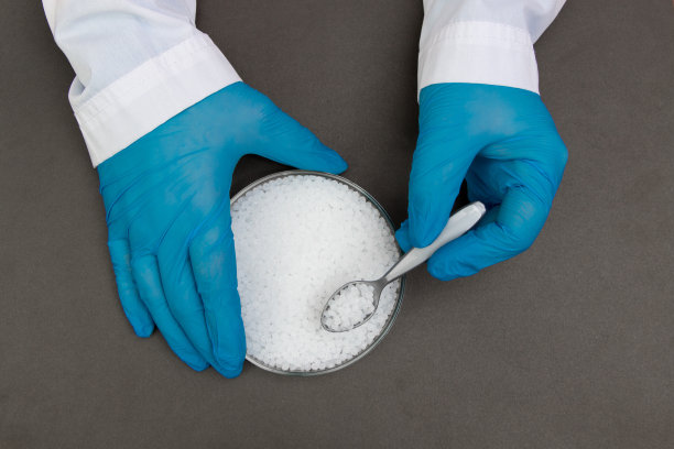 塑料颗粒。聚丙烯，聚乙烯球在手与手套。生产过程中实验室塑料的质量控制图片下载