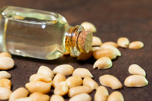 花生油在一个棕色的背景特写。有选择性的重点。油在烹饪、饮食、美容等方面的应用，是皮肤护理产品的优良成分图片下载