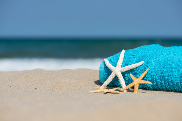 夏日度假概念毛巾与太阳镜和海星在热带沙滩-选择性焦点，复制空间图片下载