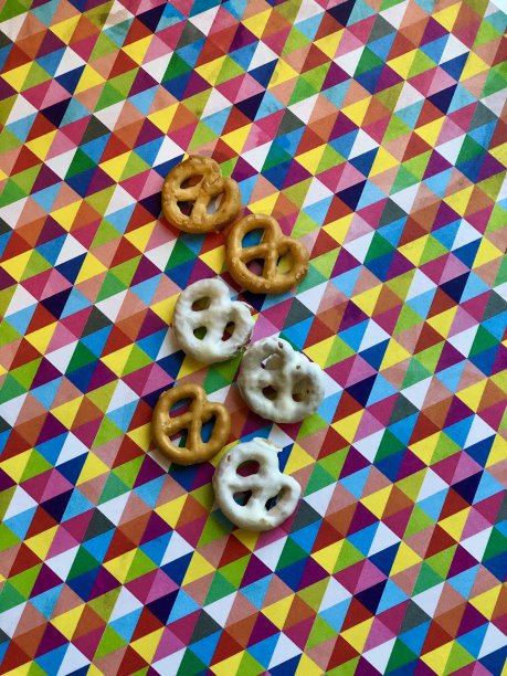 彩虹背景上的椒盐卷饼图片下载