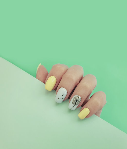 女性手指甲美丽的指甲上的彩色纸背景图片下载