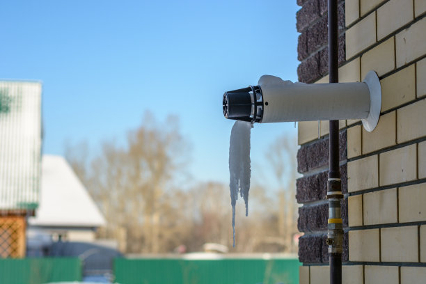 锅炉烟囱煤气管从私人住宅的砖墙中伸出。雄厚的加热图片下载