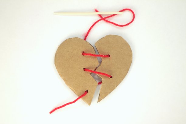 在背景上用红线缝着破碎的纸板心。图片下载