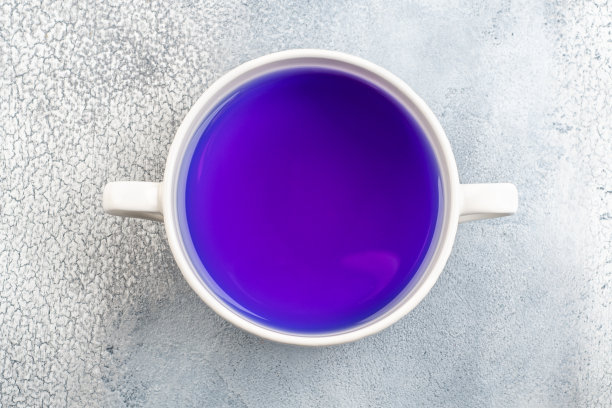蝴蝶豌豆花蓝茶。健康的排毒草药饮料在光的背景图片下载