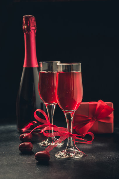 情人节和生日贺卡与礼物和红色起泡酒在黑色。图片下载