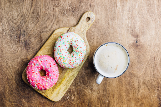 多彩的甜甜圈早餐组成与不同的颜色风格的甜甜圈和新鲜的咖啡在木制的背景。前视图。平躺图片下载