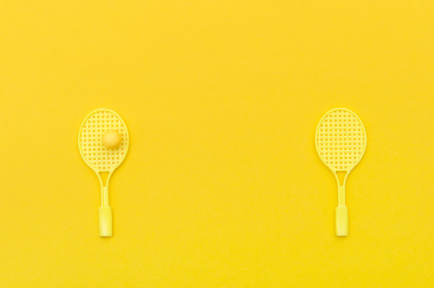 黄色背景上的网球拍和球类运动。图片下载