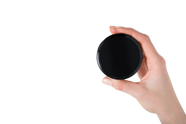 黑色的圆形罐子，女性手中的霜和化妆品。孤立在白色的。正上方图片下载