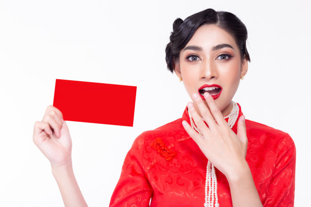 迷人美丽的女人收到红包。迷人的美丽的年轻女士得到惊喜和感到幸福。漂亮的中国女人在中国新年穿中国服装或旗袍。孤立的图片下载