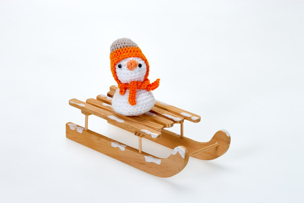 木制雪橇，上面坐着编织娃娃图片下载