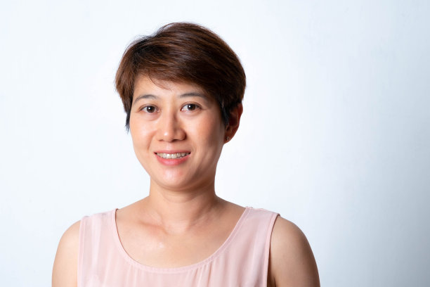 在白色背景上微笑的短发亚洲妇女的肖像图片下载