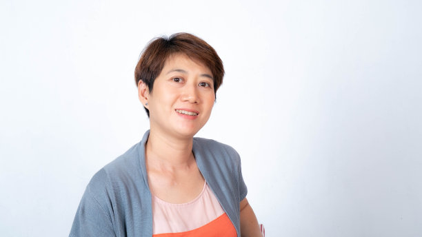 在白色的背景上，一个短头发的亚洲妇女面带微笑的肖像图片下载