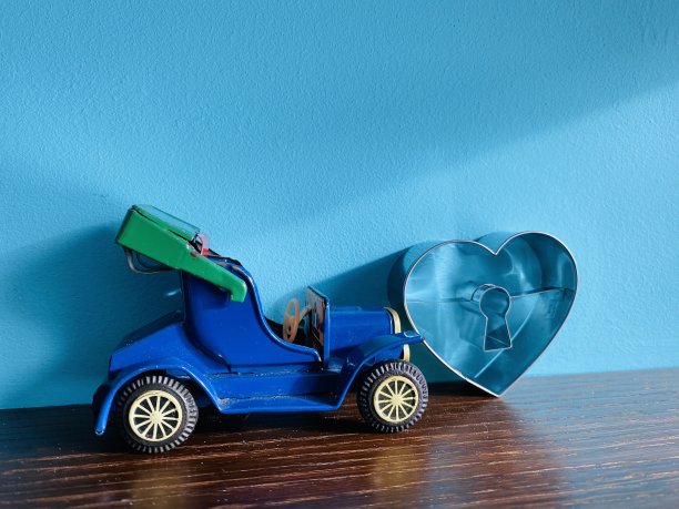 心形的钥匙孔和一个玩具concerible汽车在蓝色的背景图片下载