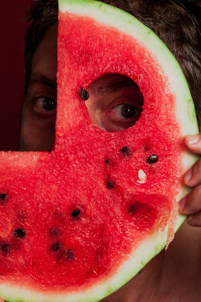 男人的眼睛透过一片红色的西瓜图片下载