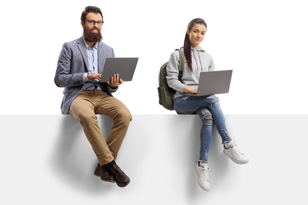 一名女学生和一名大胡子男子坐在一块白板上使用笔记本电脑图片下载
