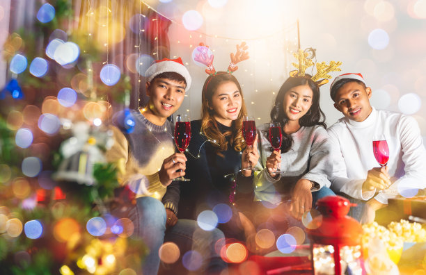 一群亲密的朋友正在聚会在圣诞节或新年前夕在客厅，每个人都拿着酒杯和碰杯，愉快地在这个冬天的季节庆祝。图片下载