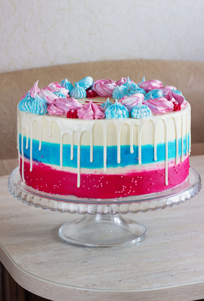 明亮的节日蛋糕与多种颜色的蛋白霜在桌子上，在一个明亮的背景，节日性别的未出生的孩子图片下载