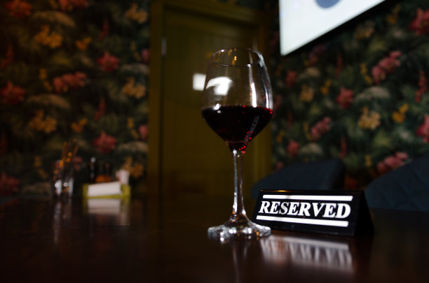 一杯红酒和背光背景上的塑料招牌图片下载